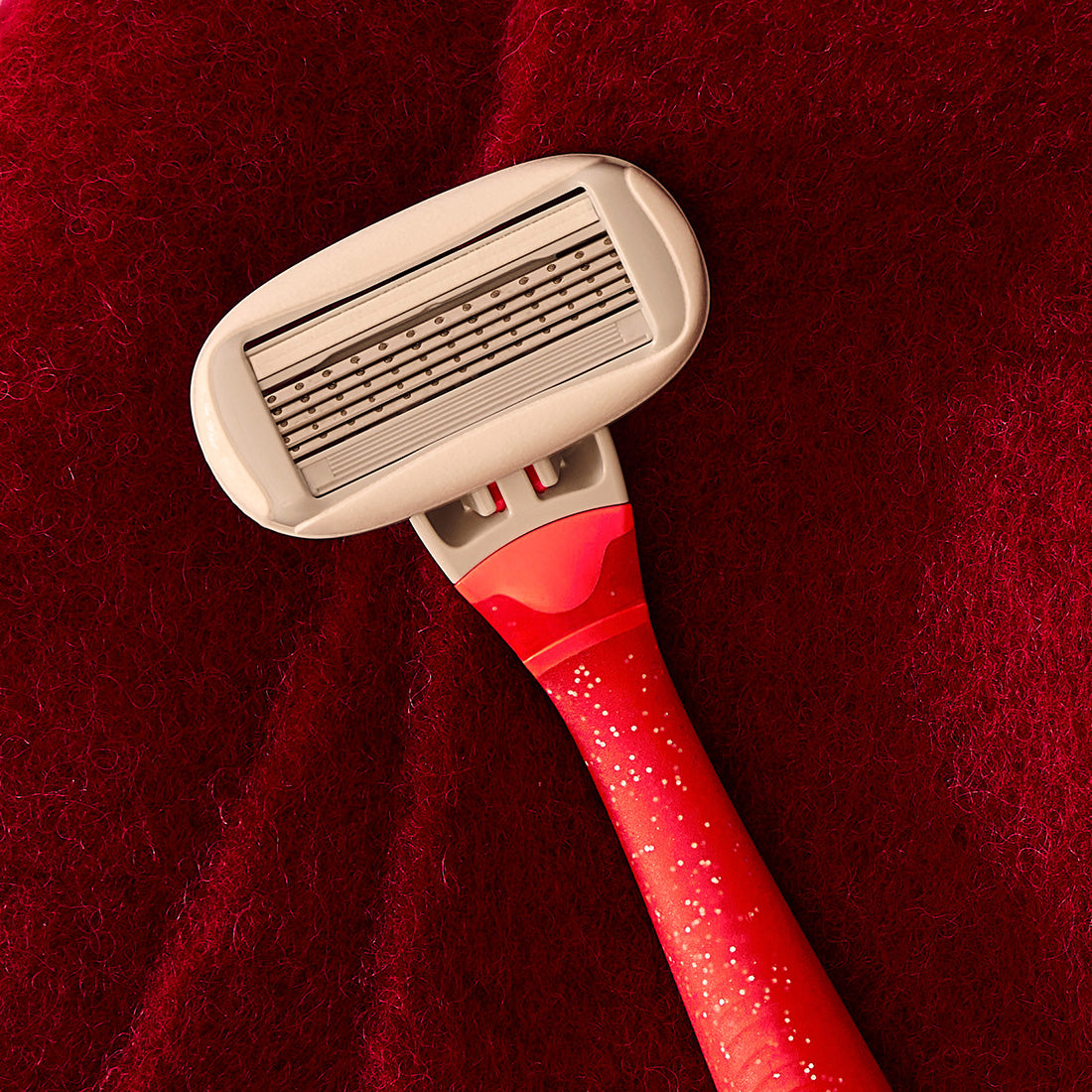 Cranberry Fizz Original Razor Handle on a red fuzzy background.