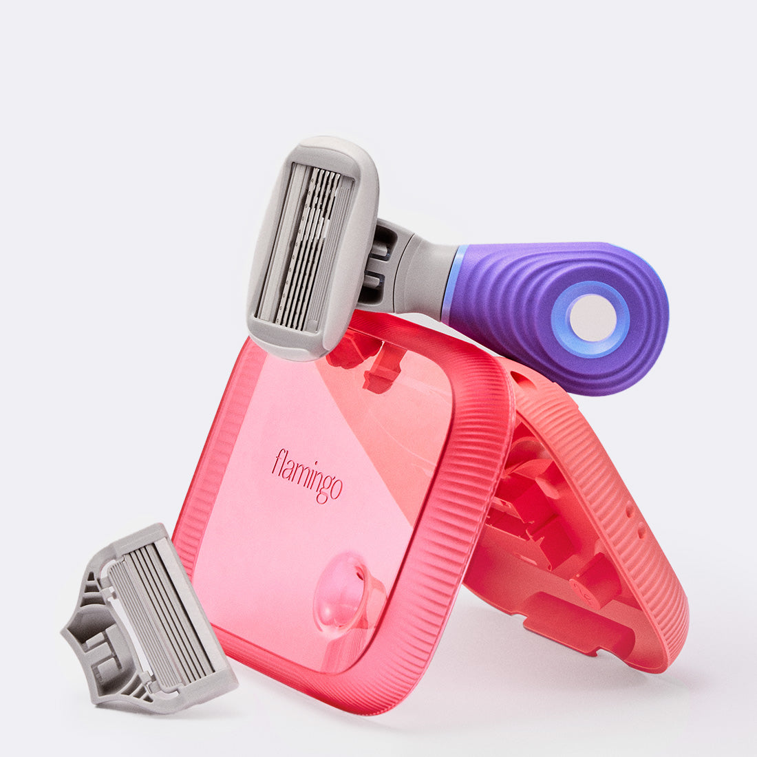 Purple mini razor resting on a pink travel case.