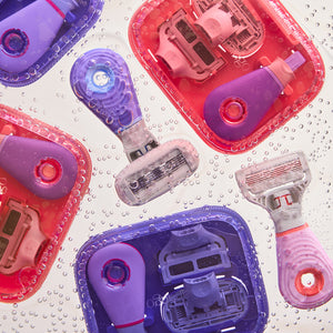 Pink and Purple travel razors with cases on a bubbly background. 