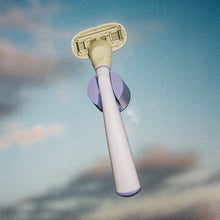 Lilac Original Razor in its holder set an evening sky background.