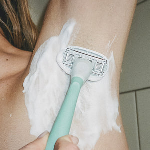Close up of a person using the Sage Original Razor and shave gel to shave their underarm.