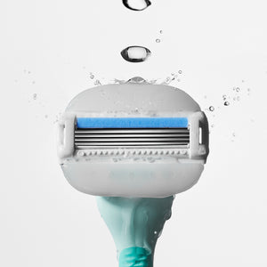 Close up of the Moisture Plus blade on the Seafoam handle with drops of water bouncing off the top.