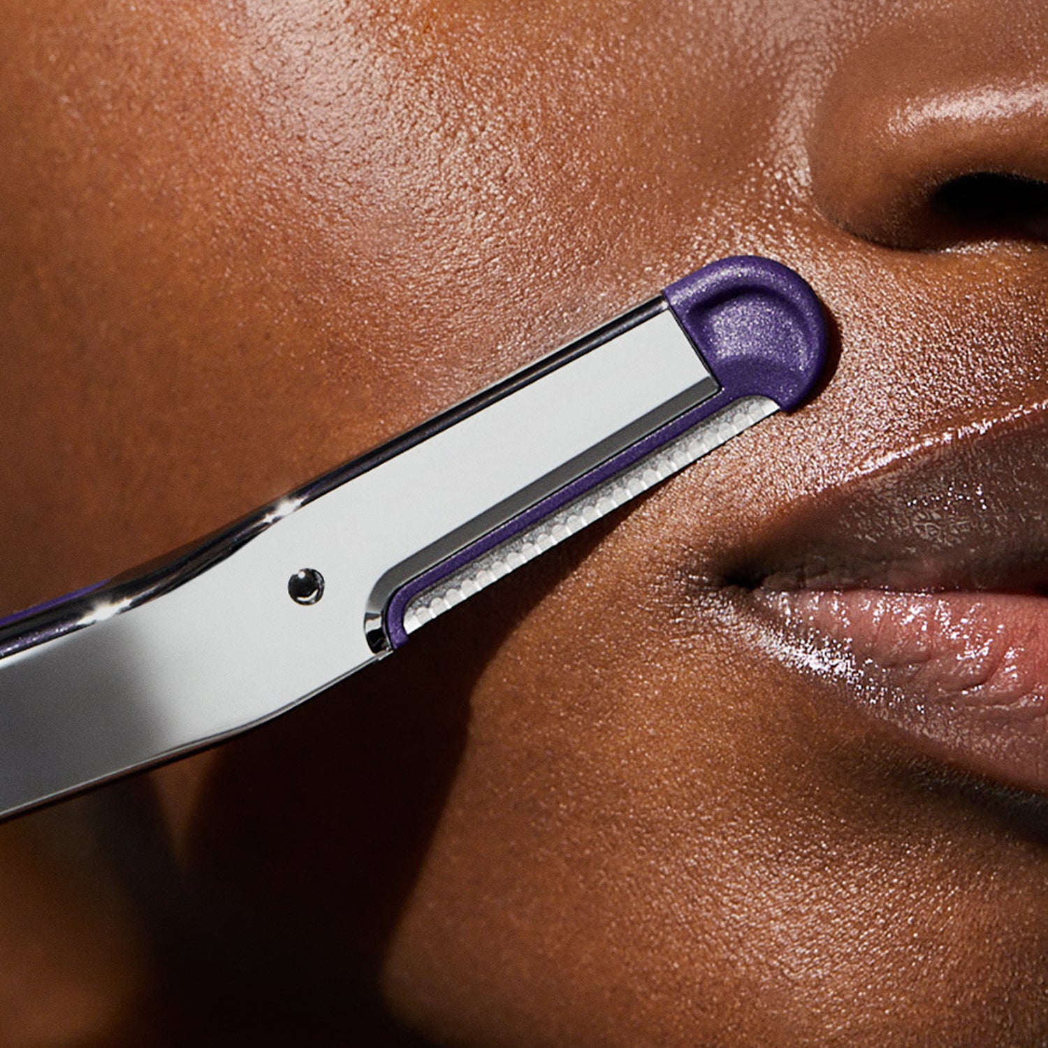Close up of a woman's face as she uses the Flamingo Refillable Dermaplane Razor on her upper lip
