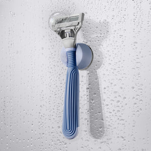 Pubic Razor in the holder on a shower wall.