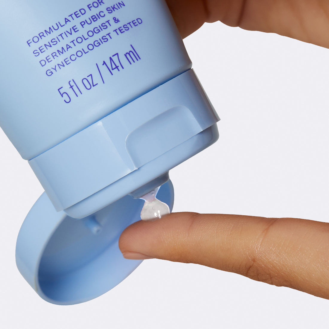 Close up of the Pubic Exfoliating Shave Gel being squeezed out of the  tube onto a persons finger.