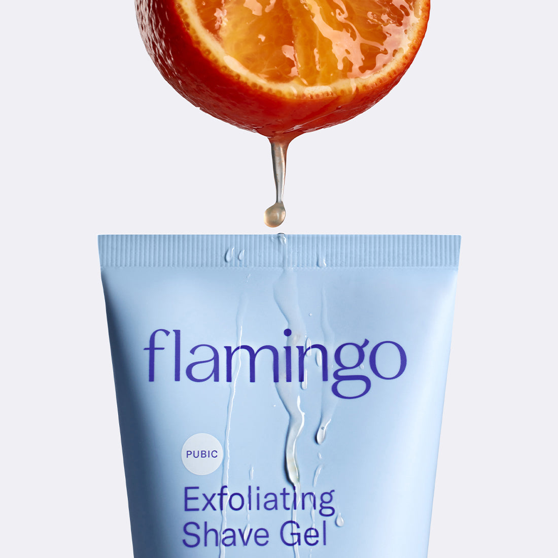 Orange slice dripping juice onto the top of the tube Pubic Exfoliating Shave Gel.
