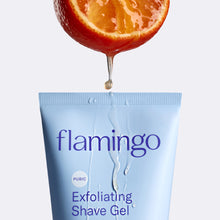Orange slice dripping juice onto the top of the tube Pubic Exfoliating Shave Gel.