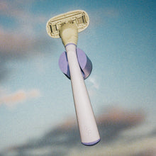 Lilac Original Razor in its holder set an evening sky background.