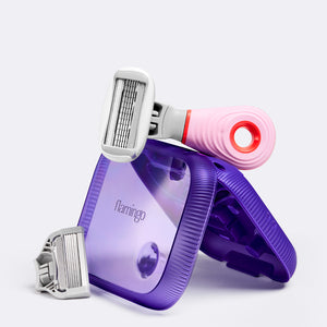 Pink mini razor resting on top of the purple plastic case.