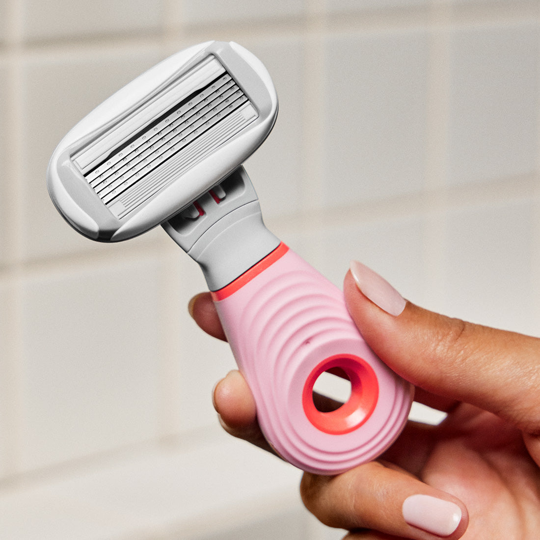 Hand holding the mini razor with an Original blade cartridge.