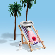 Mini razor sitting in a beach chair with palm trees and bright blue background.