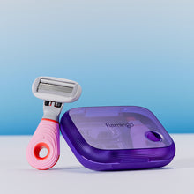 Pink mini razor resting next to the purple plastic case on a light blue background.