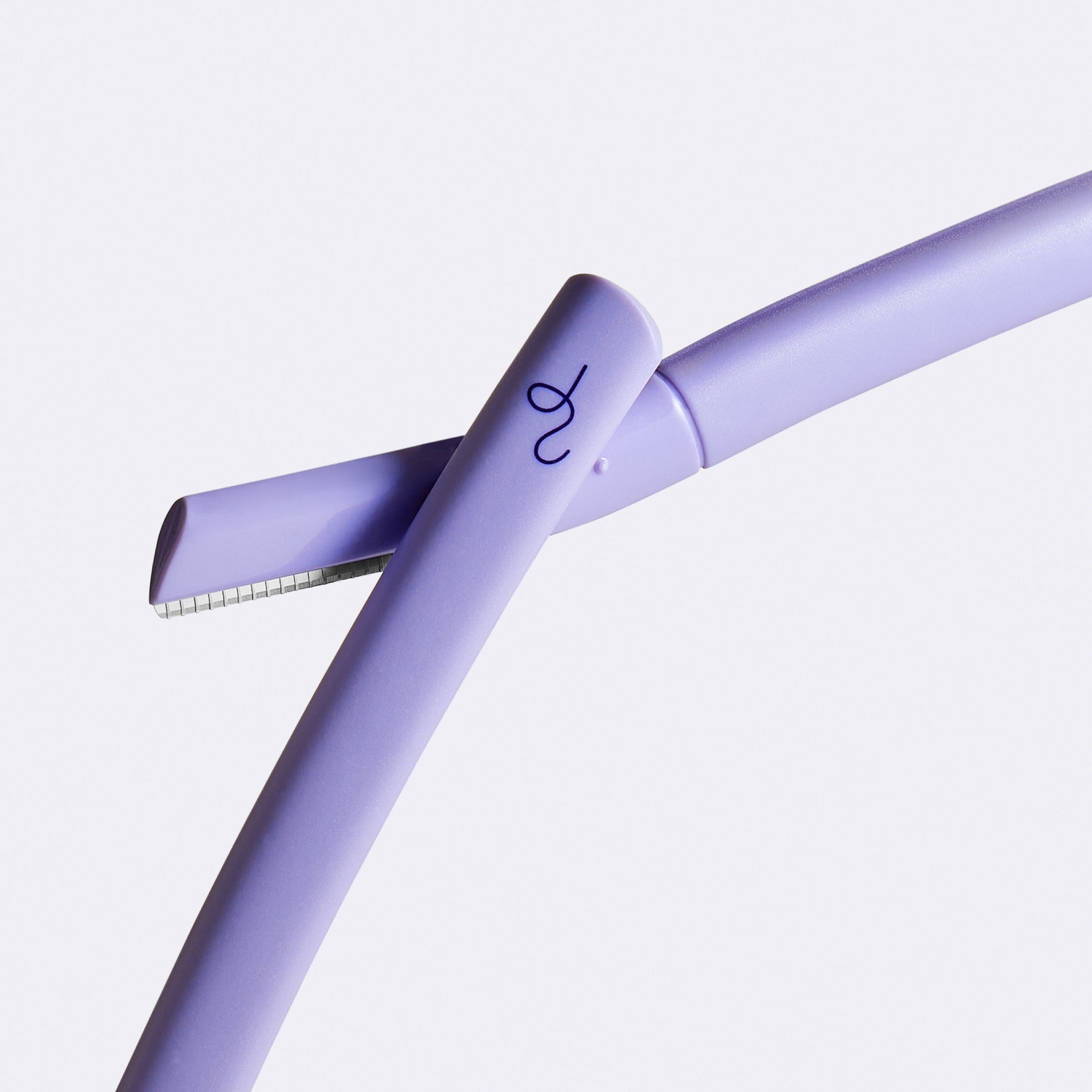 Two lilac Flamingo Disposable Dermaplane Razors crossed over one another