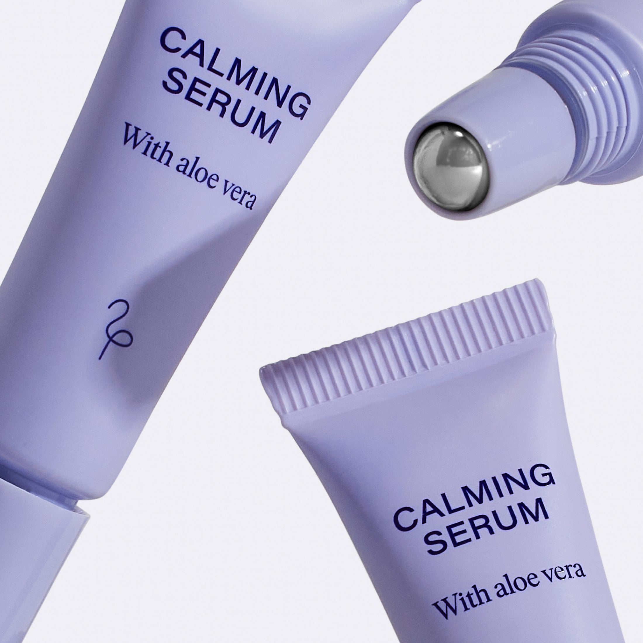 Close up three Flamingo Calming Serums showcasing the stainless steel rollerball applicator