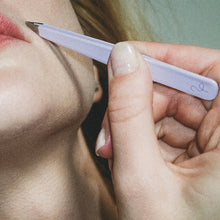 Close up of a woman using Flamingo Tweezers on her upper lip
