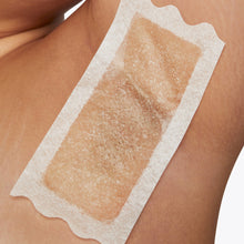 Closeup of a woman's armpit with a large Flamingo Wax strip applied