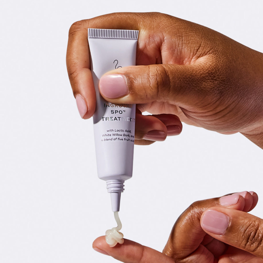 Woman squeezing a small dollop of Flamingo Ingrown Spot Treatment onto her finger