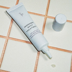 Flamingo Ingrown Spot treatment on a white tile background with terracotta grout and a small dot of the product on one tile