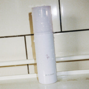 Flamingo Mons Mist in a shower holder with water droplets on it