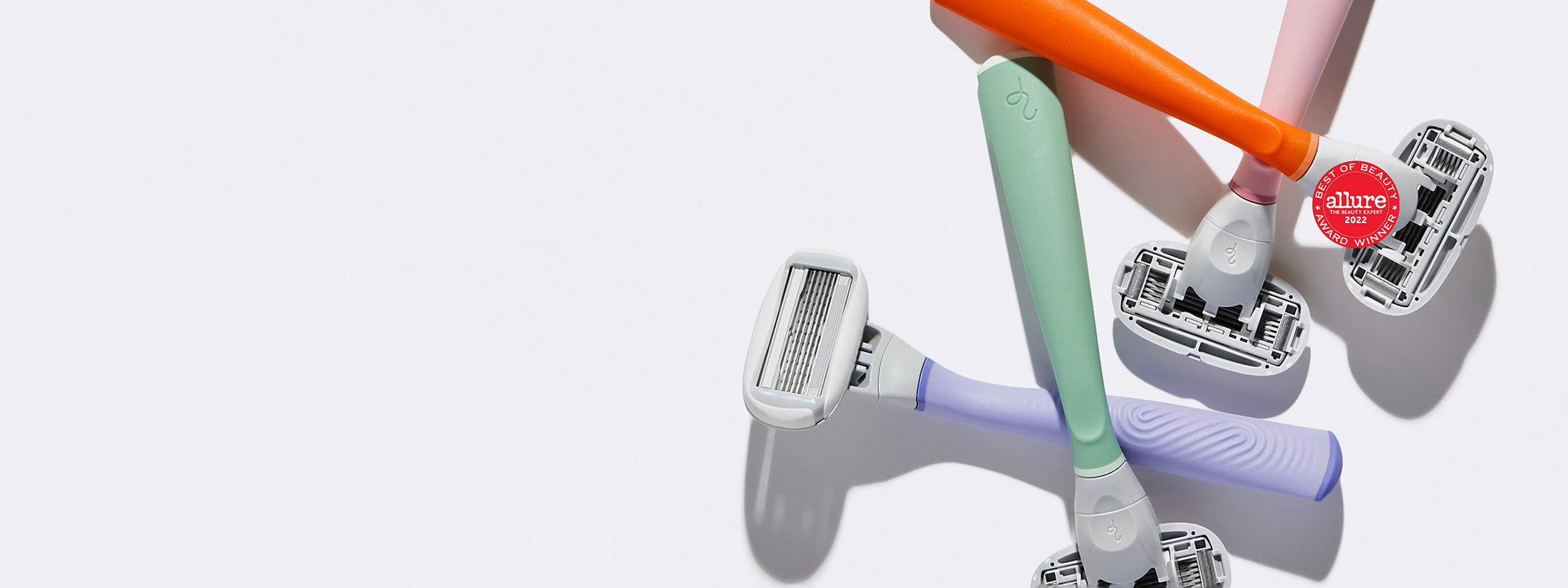 Lilac, Sage, Papaya, and Rose Flamingo Razors scattered together on a white background