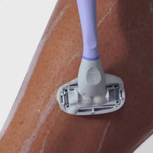 Person using the Lilac Original Razor and the Nourishing Shave Oil to shave their shin.