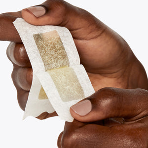 Person peeling the Pubic Wax Strips apart.