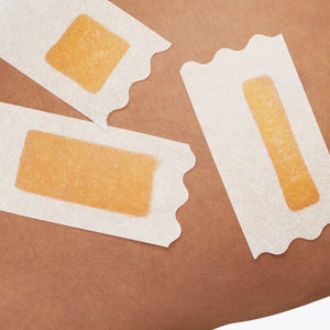 Closeup of a womans thigh with three Flamingo Wax strips applied