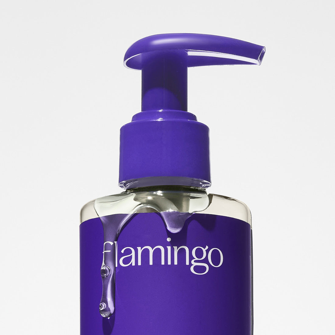 Close up of the Nourishing Shave Oil's pump packaging with the product dripping down the bottle.