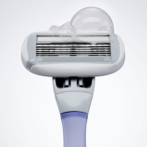 Close up of the Flamingo Razor in lilac with a small soap bubble on the blades